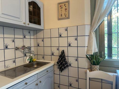 a kitchen with a sink and a tiled wall at il nuvoloso 2 in Città della Pieve