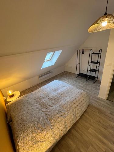 a bedroom with a bed and a ladder and a window at Gite Les 4 Moustaches in Bourbourg