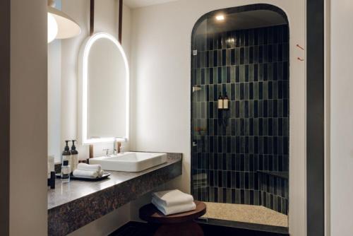 a bathroom with a sink and a glass shower at Caravan Court Hotel in Arlington