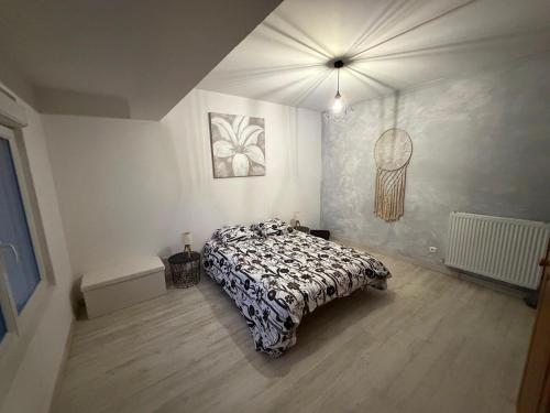 a bedroom with a bed with a black and white comforter at Nid Garona in Carbonne