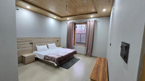 a bedroom with a bed and a tv in it at Aashvika Homes in Katrain
