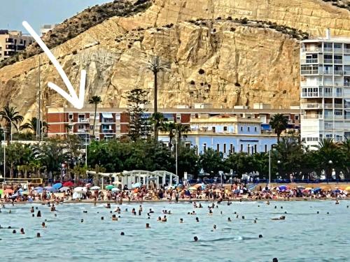 a group of people on a beach in the water at Postiguet Beach 2 garajes SuperHost SuperFlat in Alicante