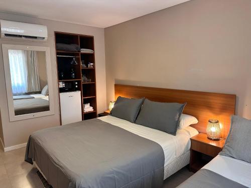 a bedroom with two beds and a mirror at Suite Rincón del Sol 107 in Pinamar