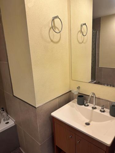 a bathroom with a sink and a mirror at Suite Rincón del Sol 107 in Pinamar