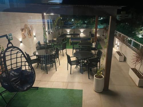 an outdoor patio with tables and chairs and plants at MAKARANDUBA BEACH 304 - Piscinas Naturais e Coração de Porto in Porto De Galinhas