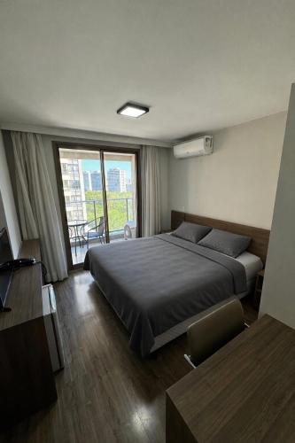 a bedroom with a bed and a large window at Suíte Master Rio de Janeiro Próximo ao Rio Centro 9 Andar! in Rio de Janeiro