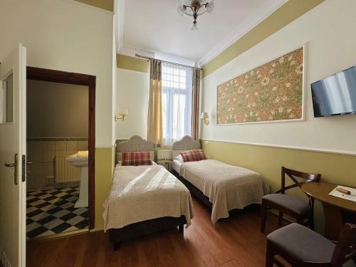 a hotel room with two beds and a bathroom at Willa Pałacyk in Świeradów-Zdrój