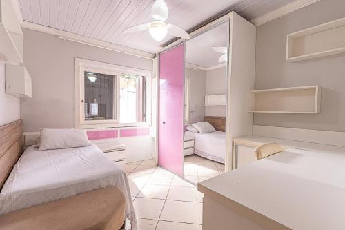 a small room with two beds and a window at Casa Atlântida in Xangri-lá