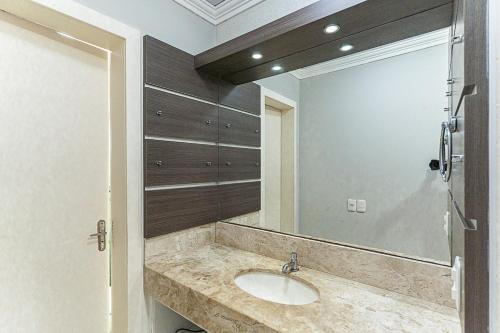 a bathroom with a sink and a large mirror at Casa Atlântida in Xangri-lá