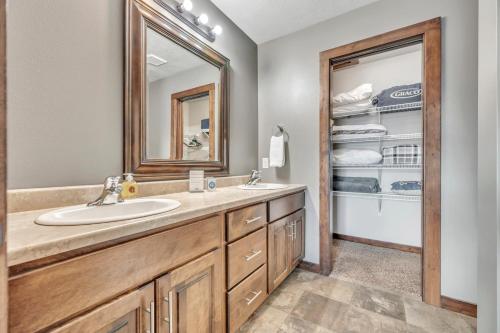 a bathroom with a sink and a mirror and a closet at Bridges Bay Vacation Cabin 278 in Arnolds Park