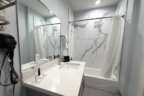 un bagno con lavandino, doccia e vasca di Hotel Royale IAH Airport North Houston I-45 a Houston
