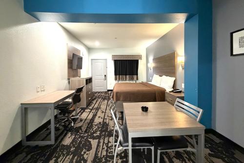 una camera d'albergo con un letto, un tavolo e delle sedie di Hotel Royale IAH Airport North Houston I-45 a Houston