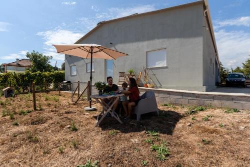 a man and woman sitting at a table under an umbrella at Casa Fermil da Graça in Veade