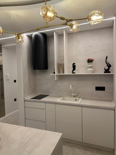 a kitchen with white cabinets and a sink at Mediteran Line Apartman 2 in Sombor