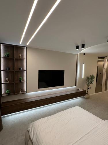 a bedroom with a flat screen tv on the wall at Mediteran Line Apartman 2 in Sombor