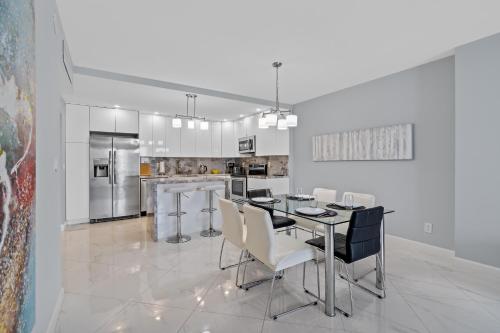 a white kitchen with a table and chairs in it at MIAMI Collins Beach Apartments in Sunny Isles Beach