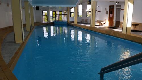 a large swimming pool with blue water in a building at Shearwater Resort in Port Sorell