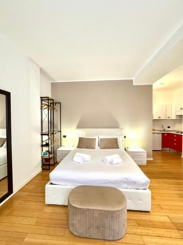 ein Schlafzimmer mit einem großen weißen Bett und einem Hocker in der Unterkunft Boutique Arena Loft in Verona
