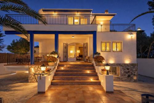 a house with stairs and lights in front of it at Villa Playa del Sur A 250 metros de una magnifica playa Capacidad más de 16 AC 6 Suites Piscina XL in Torredembarra