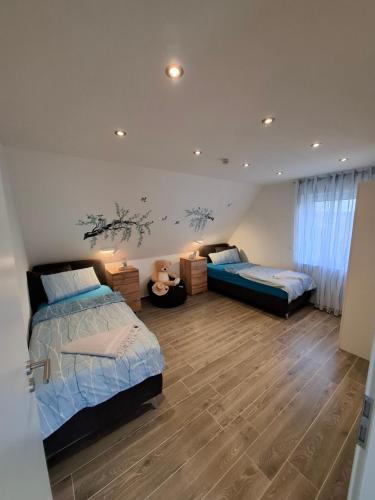 a bedroom with two beds and a teddy bear in it at Ferienwohnung bei Rheine Neubau 2026 mit Klima Terrasse ruhige Lage in Neuenkirchen