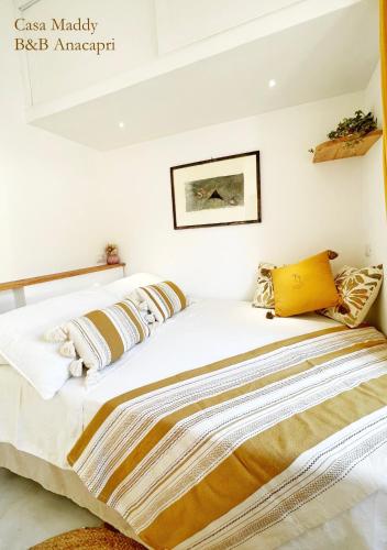 a bedroom with a large white bed with pillows at Casa Maddy Anacapri Yellow Room in Anacapri