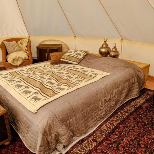 a bedroom with a bed in a tent at Stenbækgård - Farm Glamping in Højslev