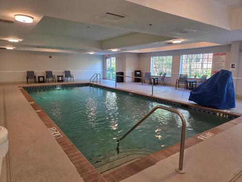 a large swimming pool in a building with tables and chairs at La Quinta Inn and Suites Fort Myers I-75 in Fort Myers