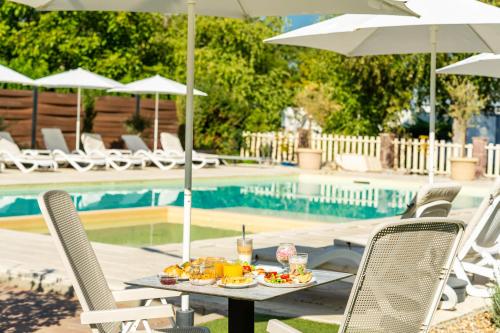 a table with food and drinks on it next to a pool at Colors Holiday Hotel in Siófok