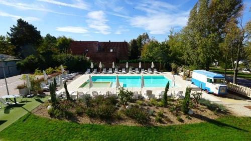 a swimming pool in a yard with chairs and an rv at Colors Holiday Hotel in Siófok