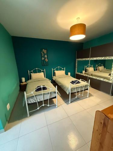 two beds in a room with green walls at Home from home at the Seacrest in St. Paul's Bay