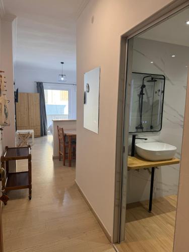 a bathroom with a sink and a mirror on a wall at Bettys rooms in Paralio Astros