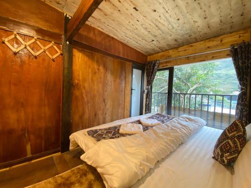 a bed in a room with a wooden wall at Km 0 home Du Già in Muong Cha