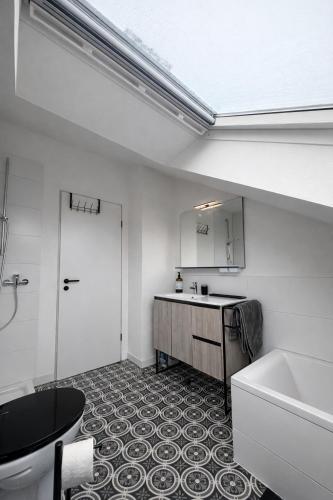 ein Badezimmer mit Toilette, Waschbecken und Badewanne in der Unterkunft Modernes Dachgeschossapartment in Singen Zentrum in Singen