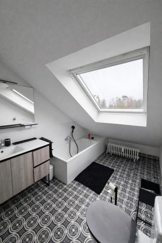 ein Badezimmer mit Badewanne, Waschbecken und Fenster in der Unterkunft Modernes Dachgeschossapartment in Singen Zentrum in Singen