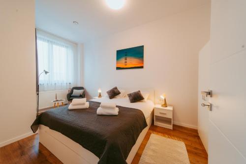 a bedroom with a bed and a chair in it at Riverline Apartman in Odorheiu Secuiesc