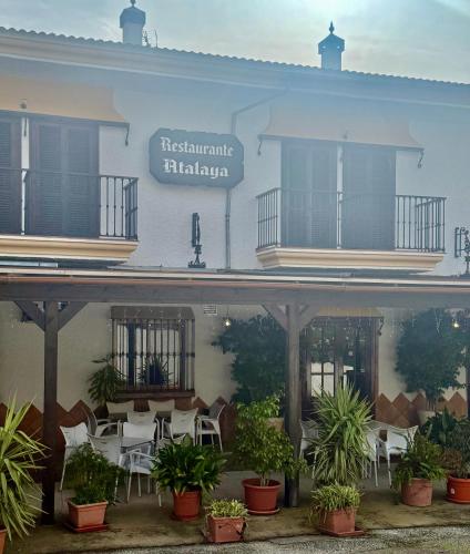 a building with a table and chairs in front of it at Hotel Restaurante Atalaya in Comares