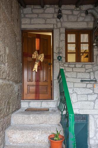 a front door of a house with a bow at Casa do Palheiro in Campo do Gerês