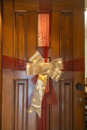 a gold ribbon bow on a wooden door at Casa do Palheiro in Campo do Gerês