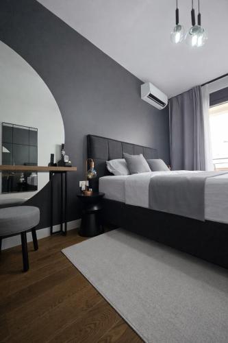 a bedroom with a bed and a table and a chair at Urban Forest Apartment - with free Garage in Podgorica