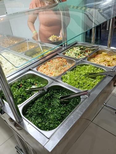 a display case with many different types of food at Pousada Nascimento in Trindade