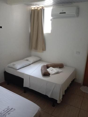 two beds in a room with a window at Pousada Nascimento in Trindade