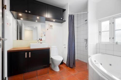 a bathroom with a toilet and a sink and a tub at BV435-Blavand-Horns-Bjerge-3-59 in Blåvand