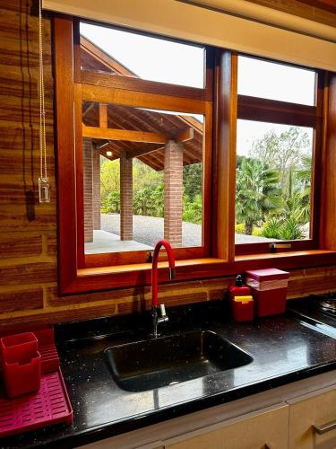 a kitchen counter with a sink and a window at Villetta Gramado Siena in Gramado
