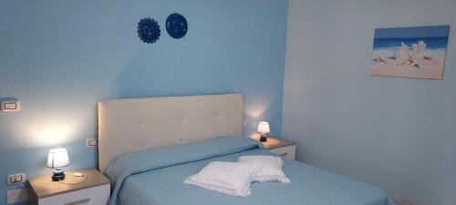 a blue bedroom with a bed with two night stands at La Rosa dei Venti B&B in Chia