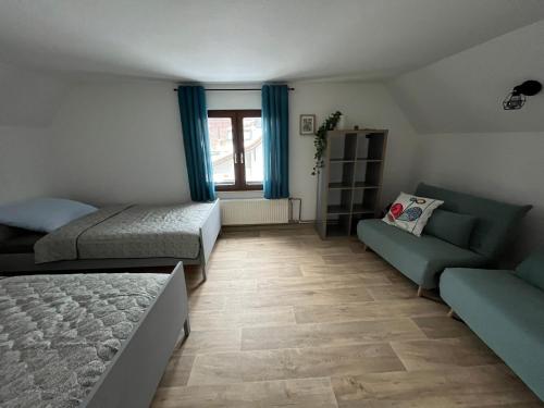 a small bedroom with two beds and a couch at Ferienhaus Kluttig in Hörnitz