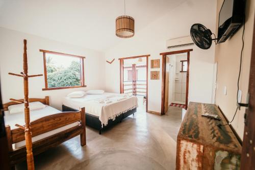 a room with two beds and a table in it at Pousada das Estrelas in Itaúnas