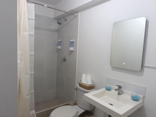 a bathroom with a toilet and a sink and a shower at The harmony suit in San Antonio