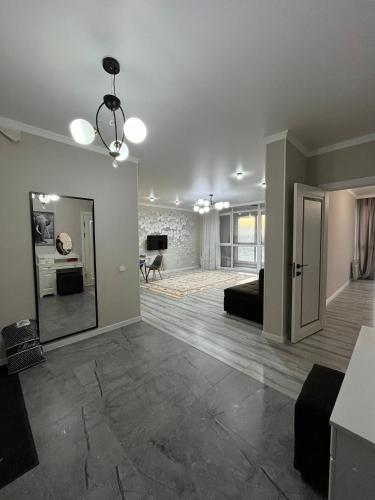 an empty living room with a couch and a mirror at ЖК City plus Евродвушка in Almaty