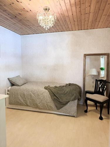 a bedroom with a bed and a mirror and a chair at Levrasjön Lake House Private Pier in Bromölla