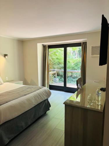 a hotel room with a bed and a large window at Hotel Villa El Descanso Express in Curicó